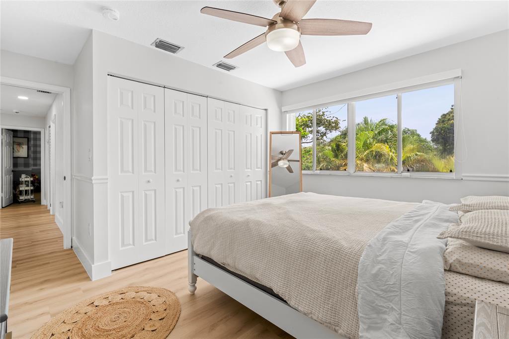 14908 Southwest 143rd Place Miami, FL 33186 - Photo 40 of 45 a bedroom with a bed and a chandelier