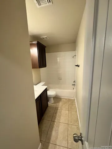 an empty room with a bathroom and a mirror