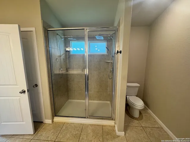 a spacious bathroom with a double vanity sink a mirror and a shower