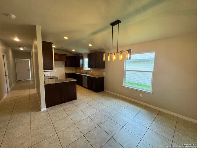 a kitchen with stainless steel appliances kitchen island granite countertop a refrigerator and a sink