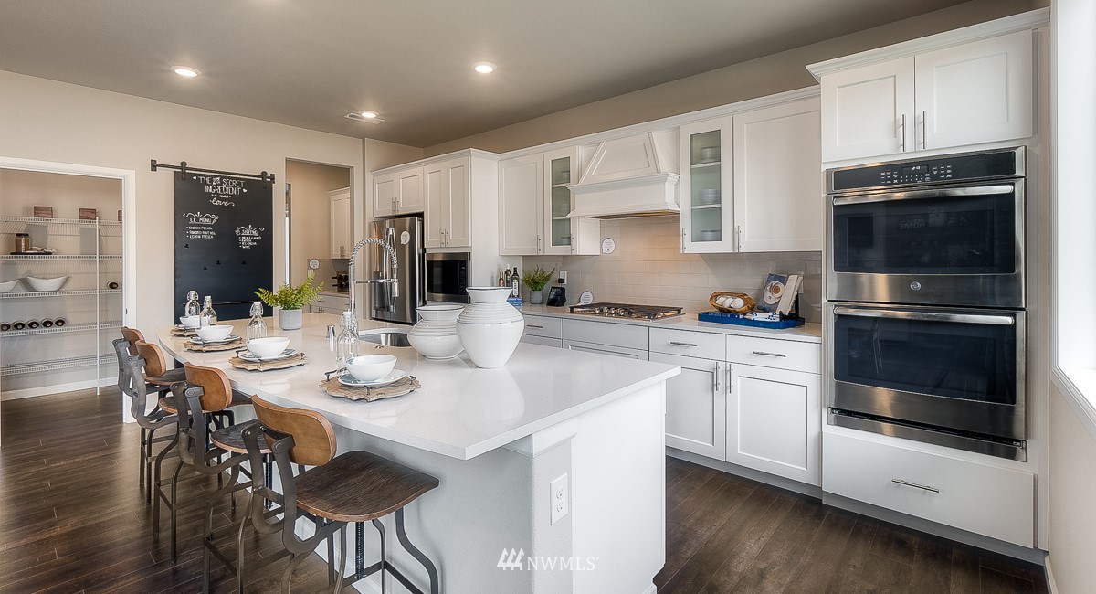4119 235th Place Southeast, Unit 37 Bothell, WA 98021 - Photo 8 of 23 a kitchen with stainless steel appliances kitchen island granite countertop a stove a sink a microwave and cabinets