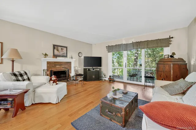 a living room with furniture a large window and a fireplace