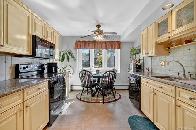 a kitchen with stainless steel appliances granite countertop a stove top oven a sink dishwasher a dining table and chairs with wooden floor