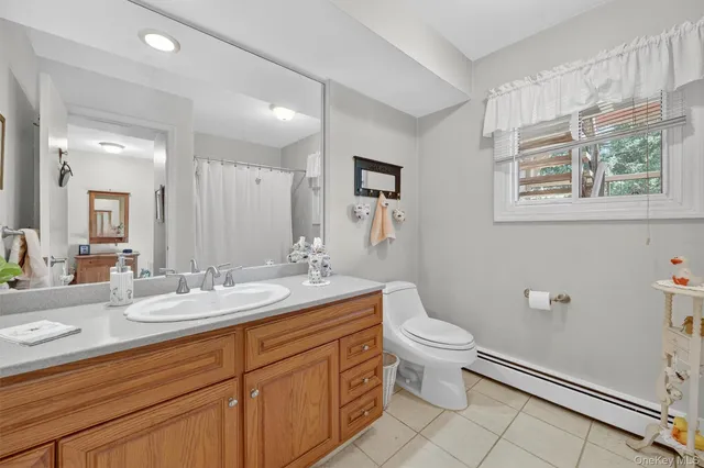 a bathroom with a granite countertop sink mirror and a toilet