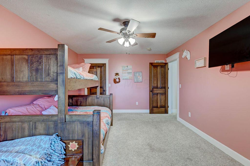 4045 Russell Road Mount Gilead, OH 43338 - Photo 31 of 74 • Gray carpet • Pink painted walls • Walk-in closet • Lighted ceiling fan • Custom built-in drawers