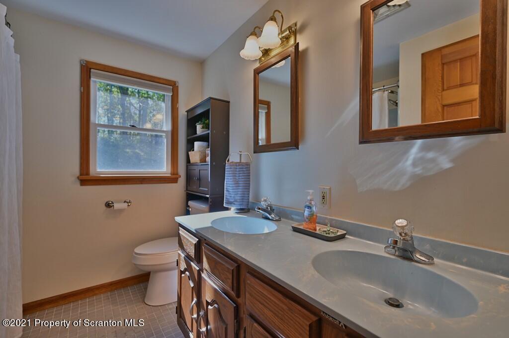 113 Marcy Road Tunkhannock, PA 18657 - Photo 53 of 82 a bathroom with a granite countertop sink a toilet and a mirror