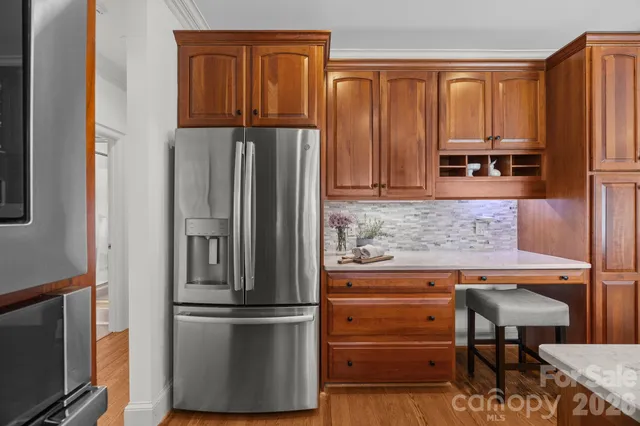 a kitchen with stainless steel appliances granite countertop a refrigerator and a stove top oven