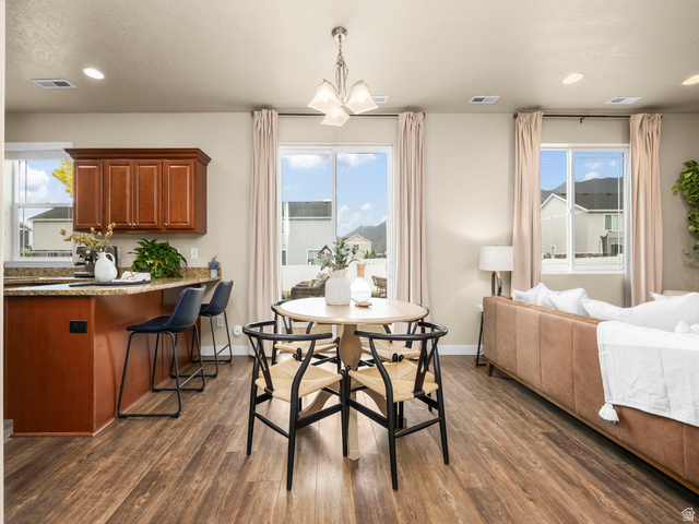 834 West 1050th Street South Springville, UT 84663 - Photo 6 of 26 Open-concept living space featuring wood-finish flooring, a kitchen island with stone-look countertops, and rich wood cabinetry