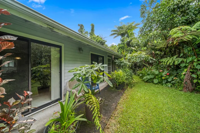 a view of a house with backyard and sitting area