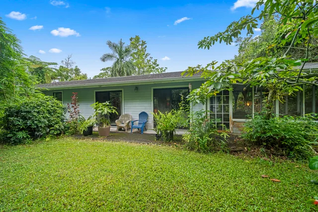 a view of a house with potted plants and a table and chairs