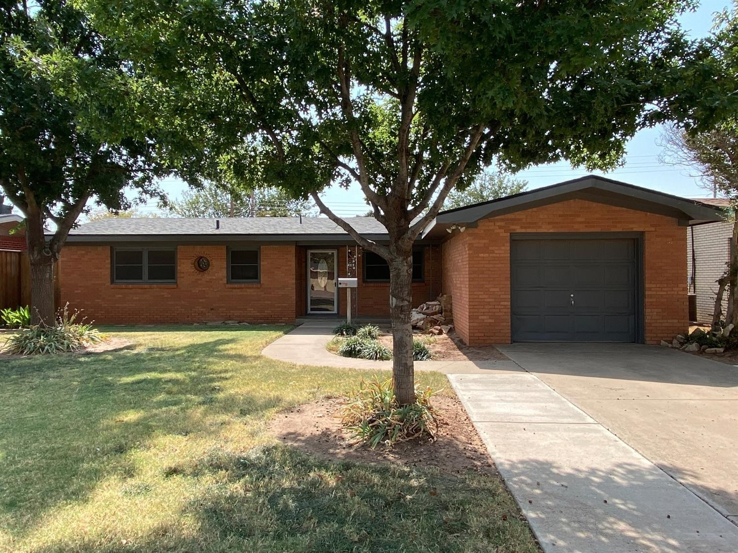 4819 44th Street Lubbock, TX 79414 - Photo 1 of 14 a front view of a house with a yard and garage