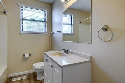a bathroom with a toilet sink and mirror