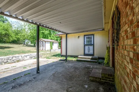 a view of house with backyard and floor to ceiling window
