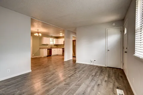 an empty room with wooden floor and a window