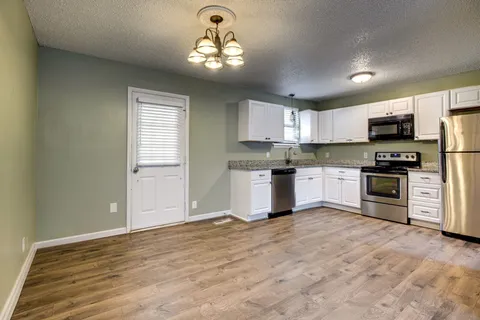a view of kitchen with sink microwave and cabinets