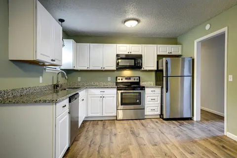 a kitchen with a sink a refrigerator and a stove top oven