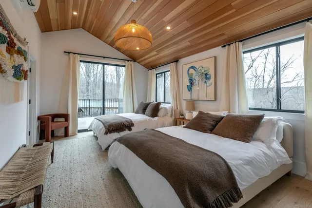 a bedroom with two beds and a large window