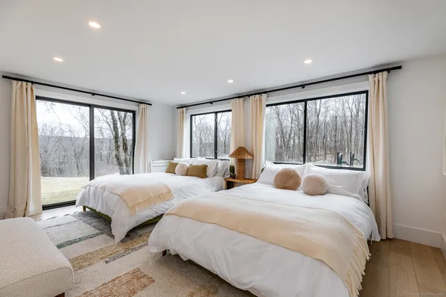 a bedroom with two beds and a large window