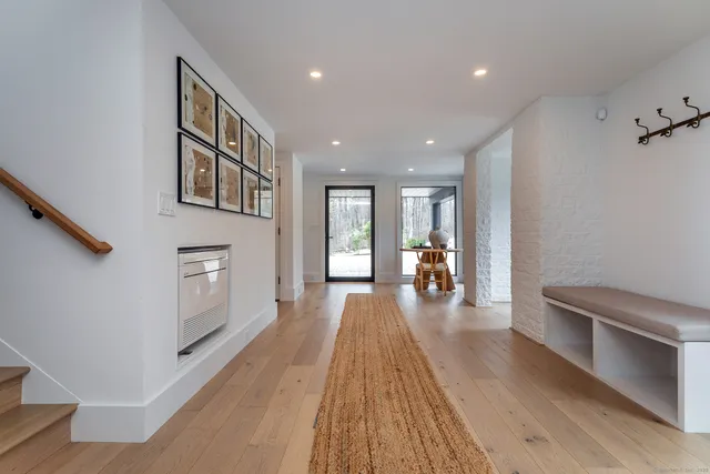a hallway with wooden floor electronic appliances and windows