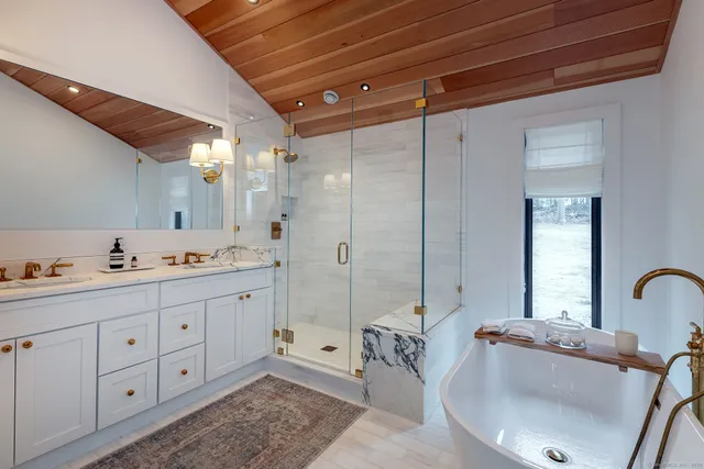 a bathroom with a tub sink and mirror