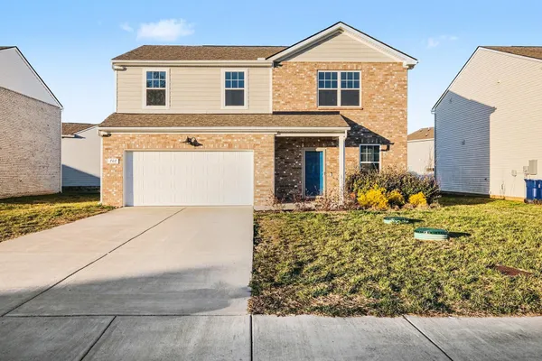 a front view of a house with a yard and garage