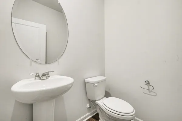 a bathroom with a sink a toilet and a mirror