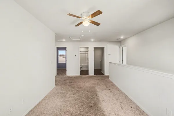 an empty room with closet and windows