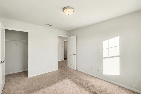 an empty room with windows and closet
