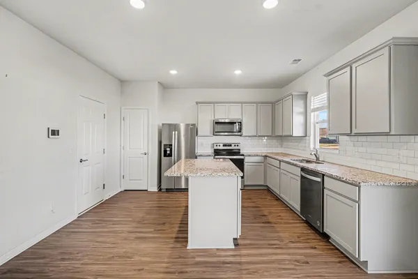a kitchen with stainless steel appliances a refrigerator sink and cabinets