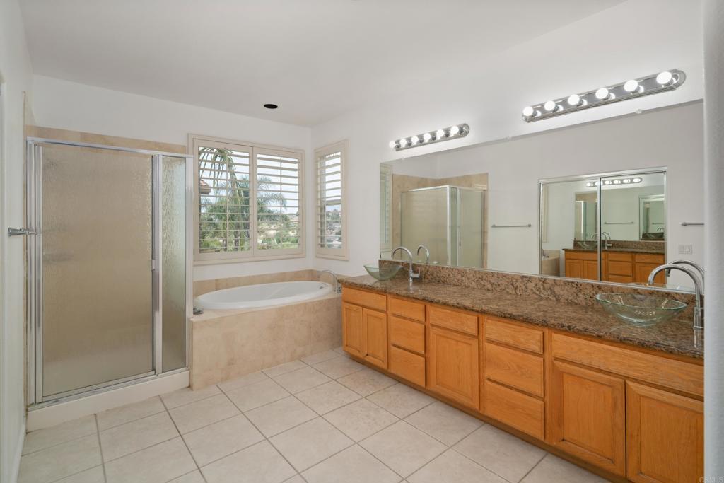 1917 Lagrange Road Chula Vista, CA 91913 - Photo 19 of 36 a spacious bathroom with a granite countertop sink a mirror a shower and a bathtub