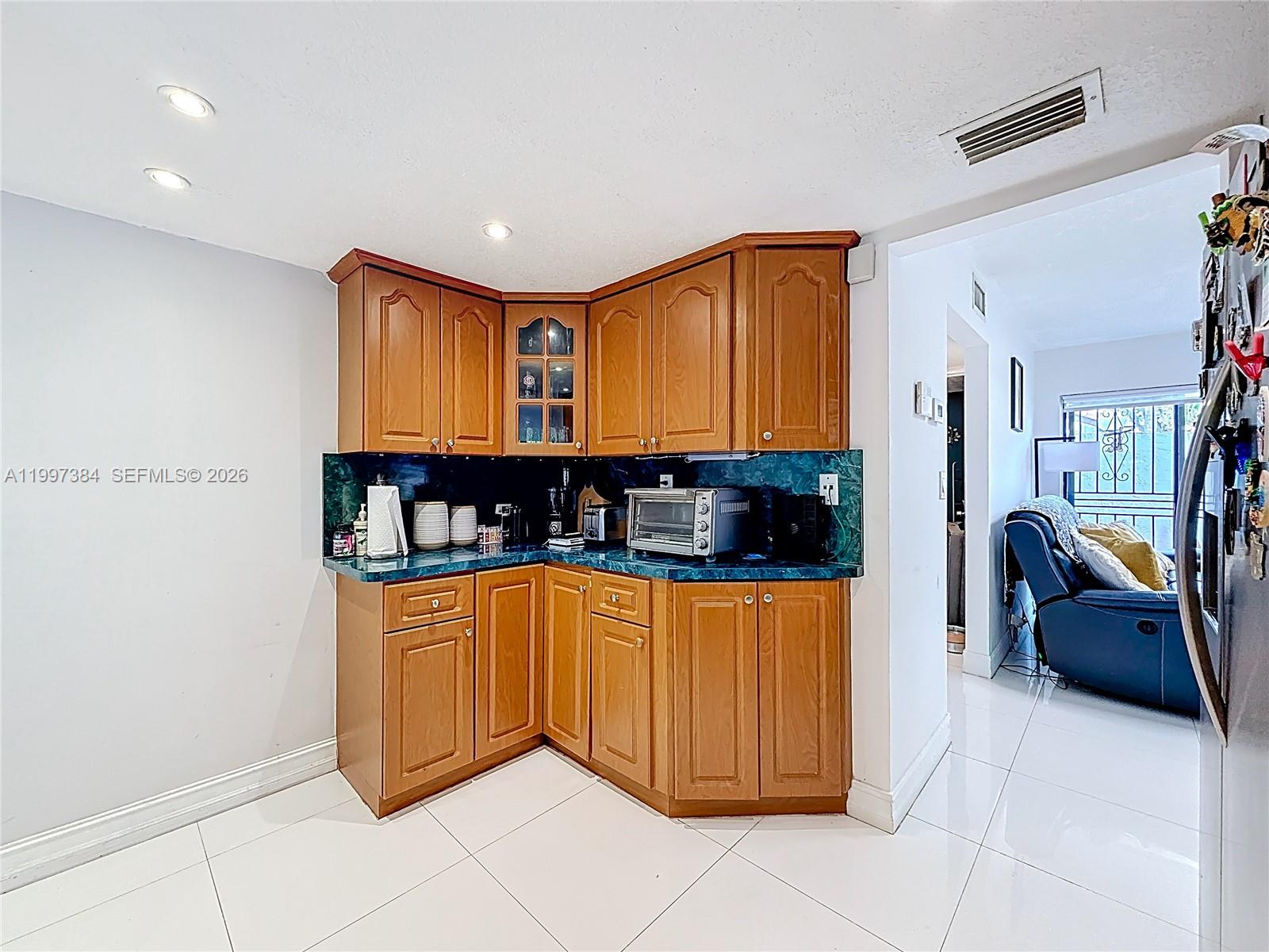 1291 Southwest 124th Court, Unit 19B Miami, FL 33184 - Photo 12 of 33 a kitchen with stainless steel appliances kitchen island granite countertop a refrigerator and a stove top oven