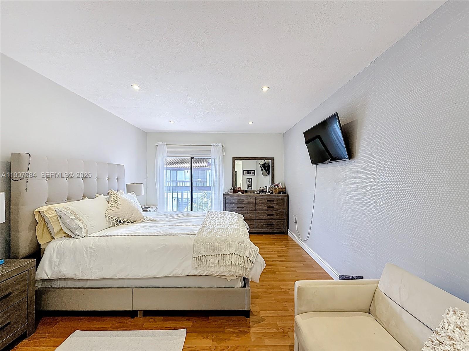 1291 Southwest 124th Court, Unit 19B Miami, FL 33184 - Photo 20 of 33 a bedroom with a bed and a television