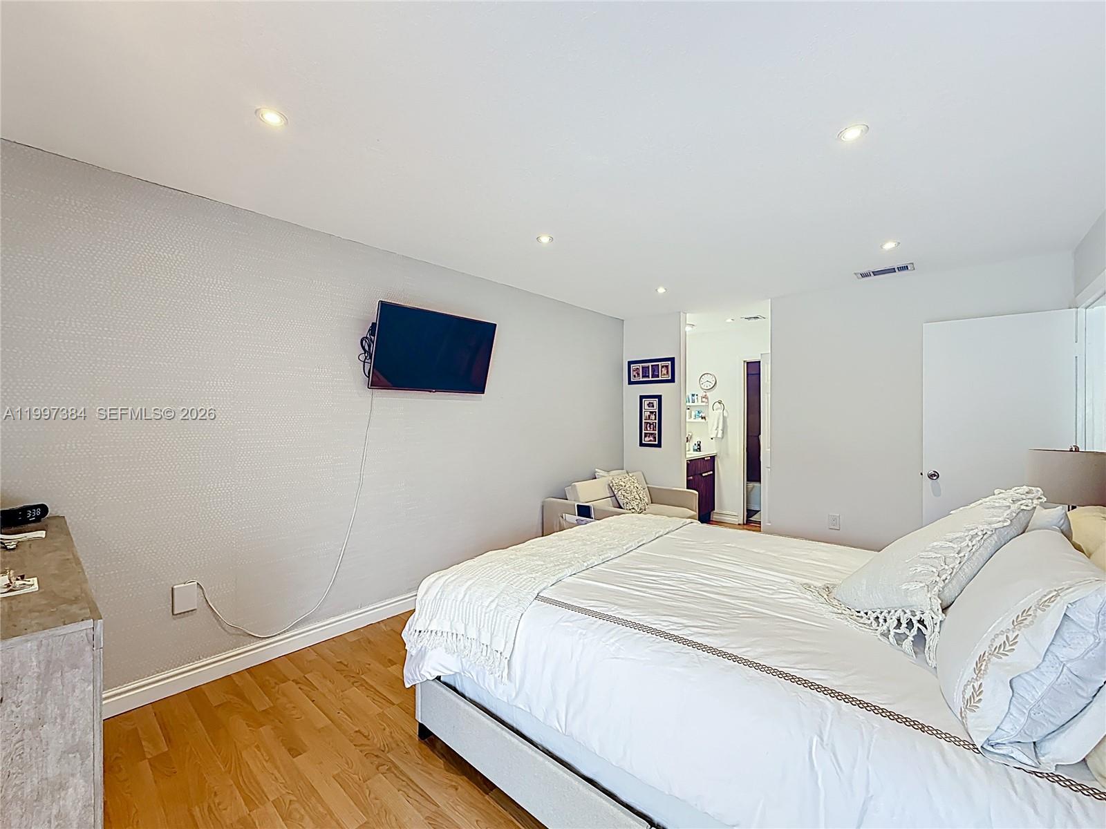 1291 Southwest 124th Court, Unit 19B Miami, FL 33184 - Photo 21 of 33 a bedroom with a bed and wooden floor