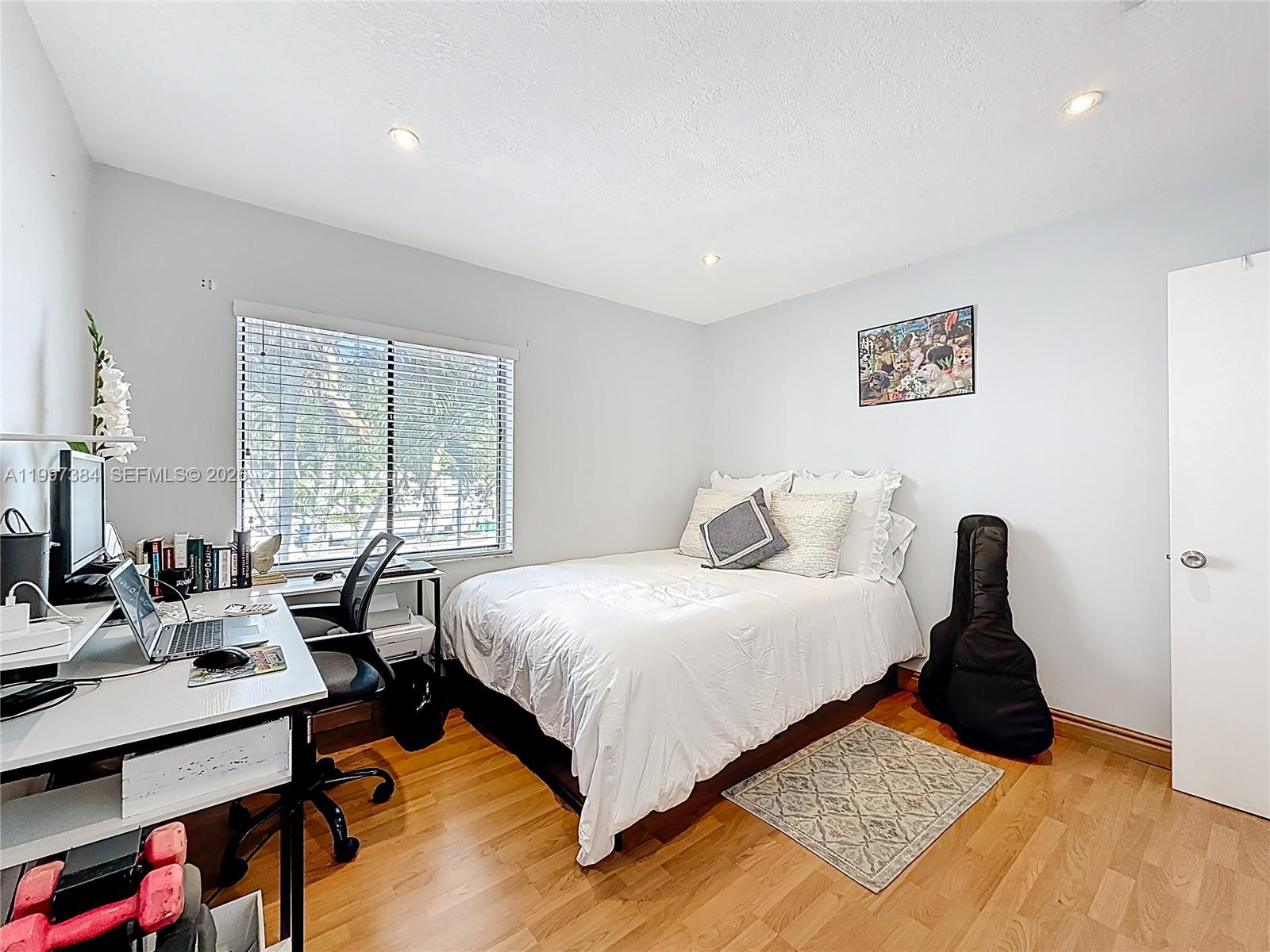 1291 Southwest 124th Court, Unit 19B Miami, FL 33184 - Photo 25 of 33 a bedroom with a bed a bookshelf and a desk