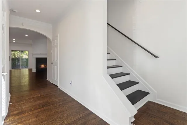 a view of a hallway with wooden floor and staircase