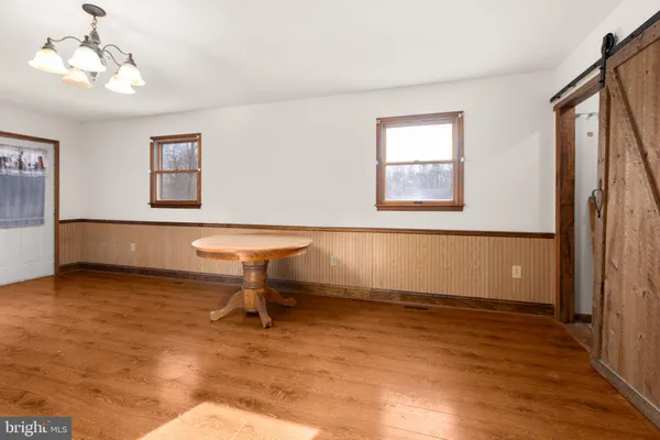 a kitchen with stainless steel appliances granite countertop a refrigerator a sink dishwasher a stove with white cabinets and wooden floor