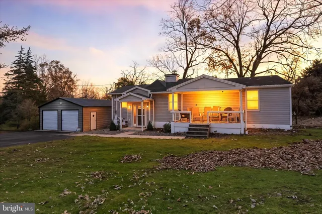 a view of a house with a big yard and large trees