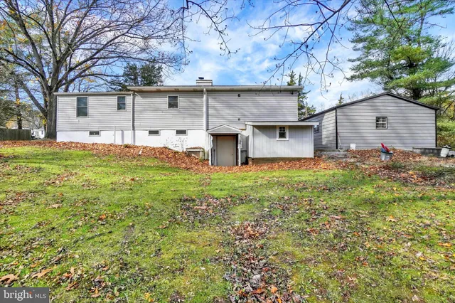 a view of a house with a large tree and a yard