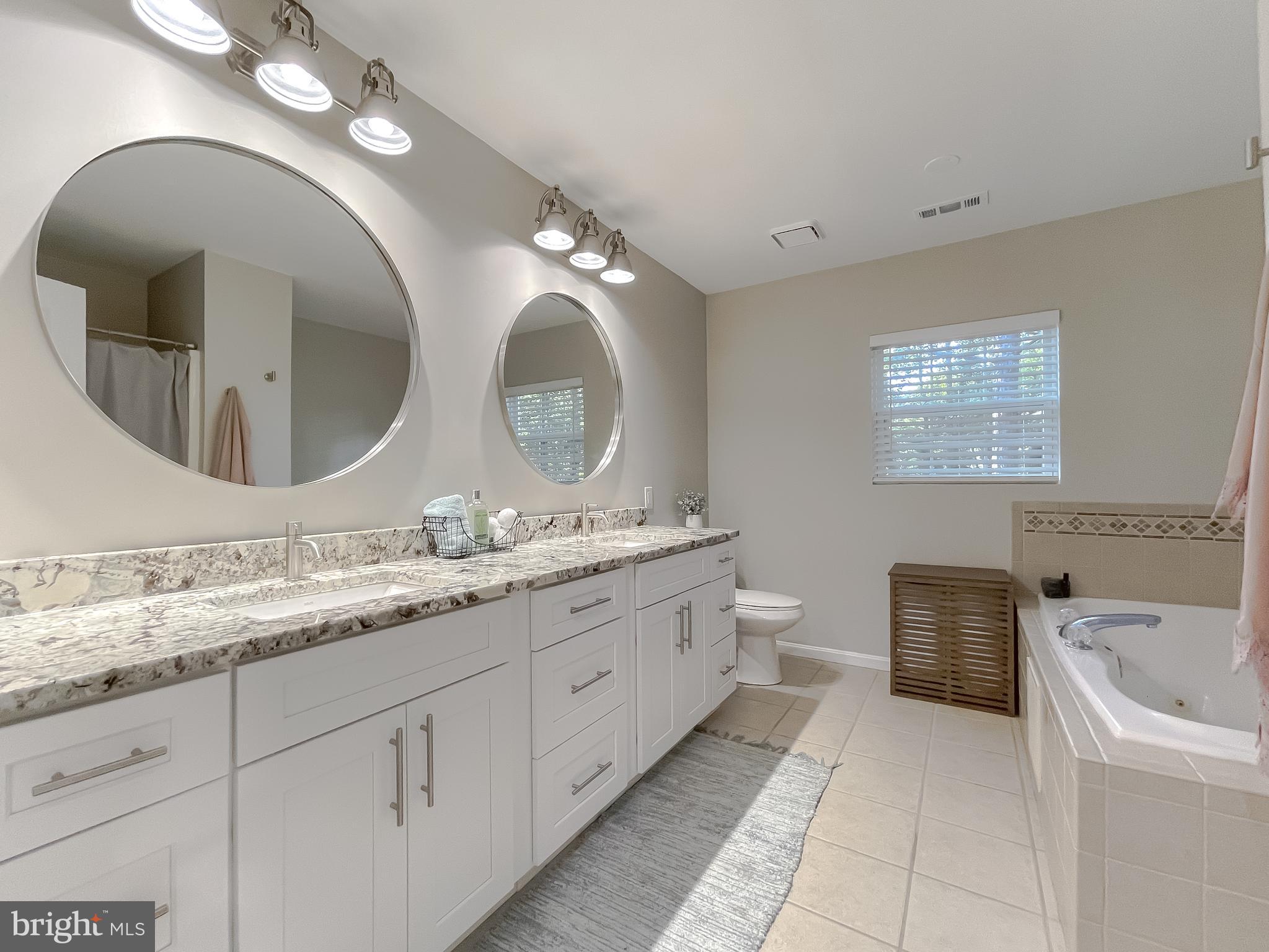 13630 Dowell Road Solomons, MD 20657 - Photo 53 of 121 a spacious bathroom with a granite countertop double vanity sink and a mirror