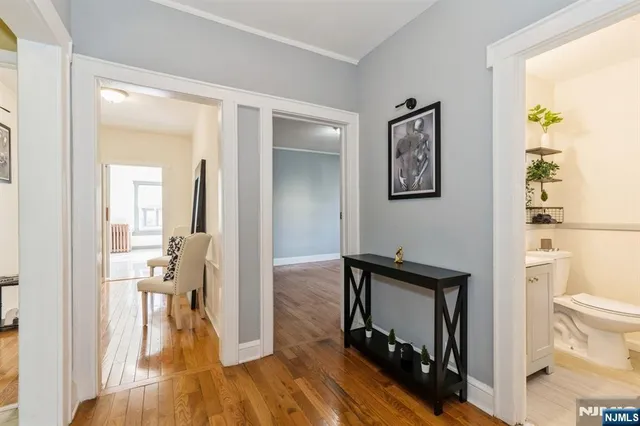 a view of a hallway with bathroom and wooden floor
