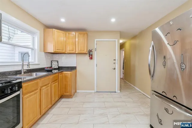 a kitchen with stainless steel appliances granite countertop a refrigerator and a sink