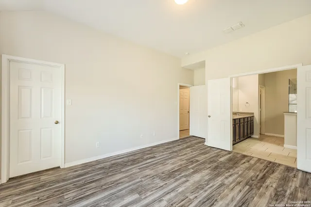 a view of a big room with wooden floor and bathroom
