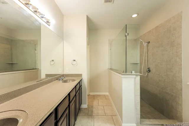 a bathroom with a granite countertop sink a shower and a mirror