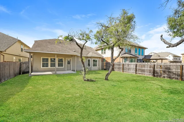 a view of a yard in front of a house with large trees