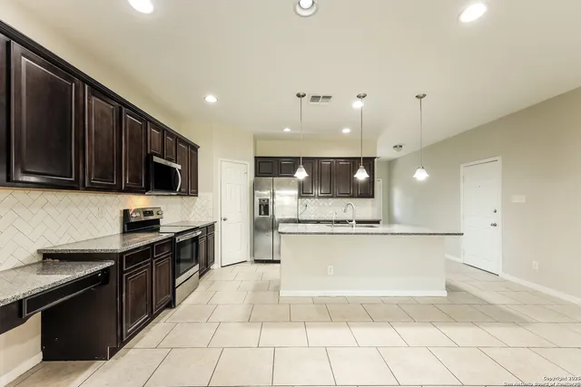 a large kitchen with a stove a sink dishwasher and a microwave oven on the stove