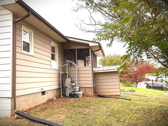 a view of house with yard and sign board