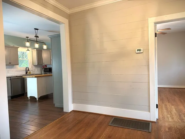 a view of a livingroom with wooden floor and a chandelier