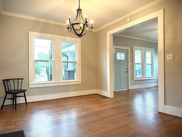 a view of an empty room with wooden floor