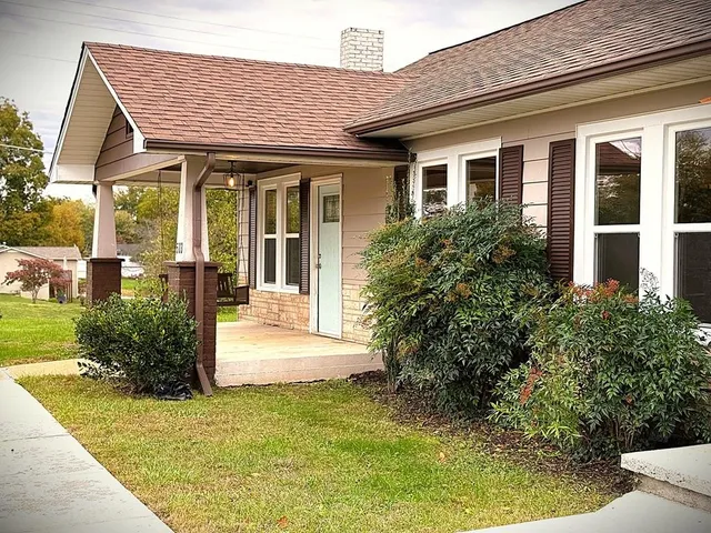 a view of a house with potted plants and a table and chairs