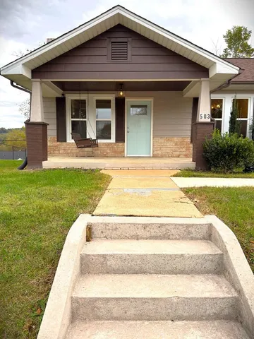 a view of house with swimming pool and yard